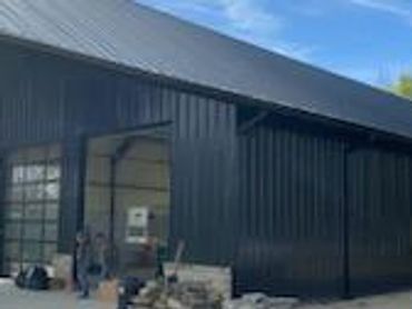 Black metal building with open garage door