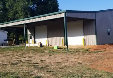 Warehouse with two loading bay doors under a canopy