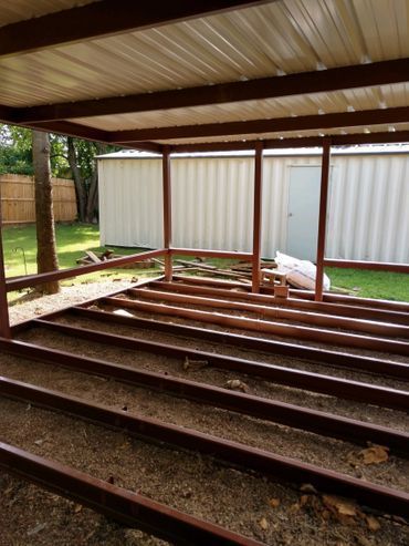 Steel-framed porch under construction with metal roof