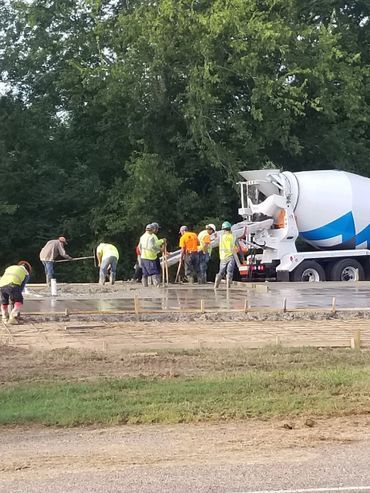 Construction workers pouring concrete from a mixer truck at a building site