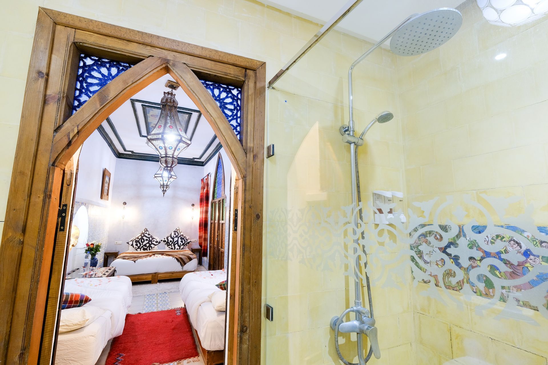 Bathroom doorway open to bedroom, traditional Moroccan design, shower visible.