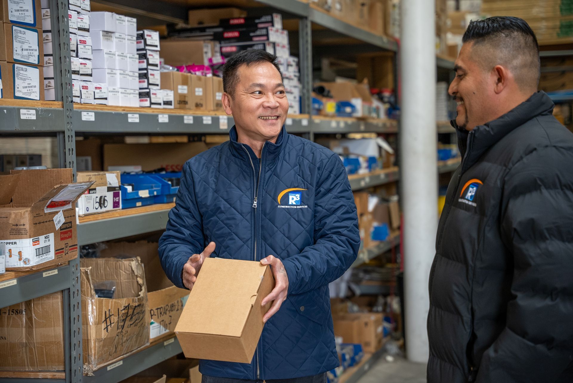 Two men in a warehouse with a cardboard box