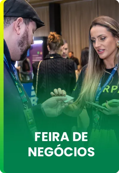 Duas pessoas trocando cartões de visita em uma feira de negócios, com o texto 