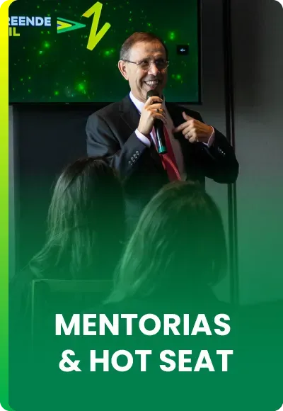 Uma pessoa falando ao microfone para uma plateia, com o texto 