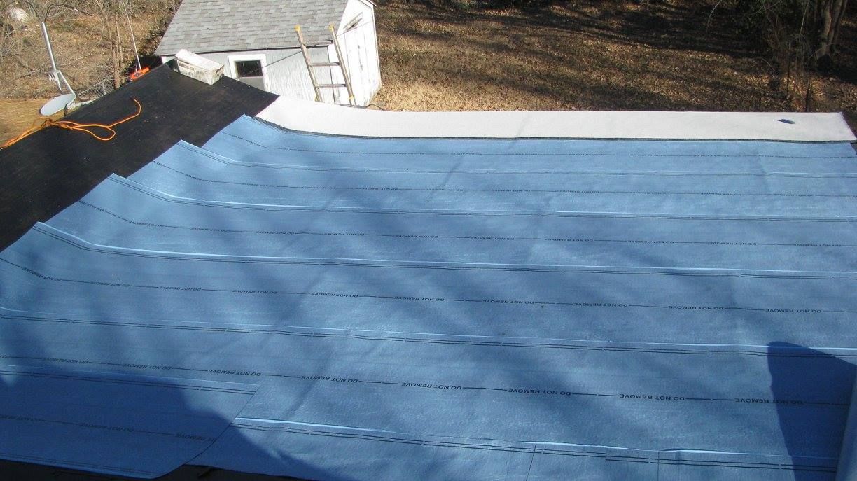 A blue roof is being installed on a house.