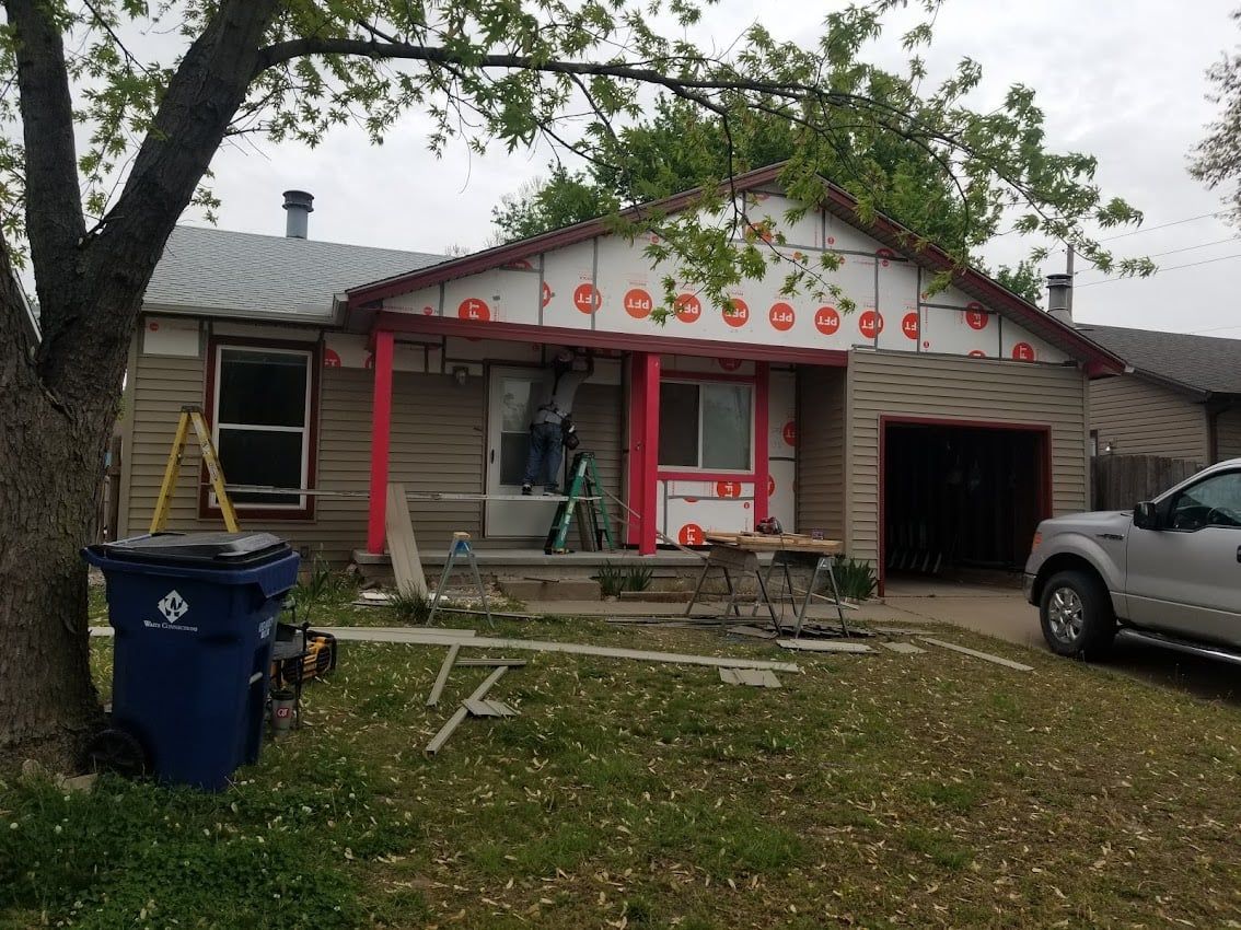 A white truck is parked in front of a house that is being remodeled