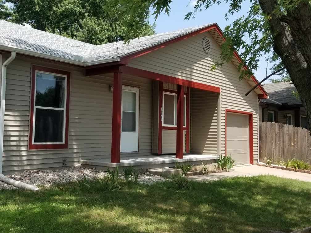 A small house with a porch and a garage