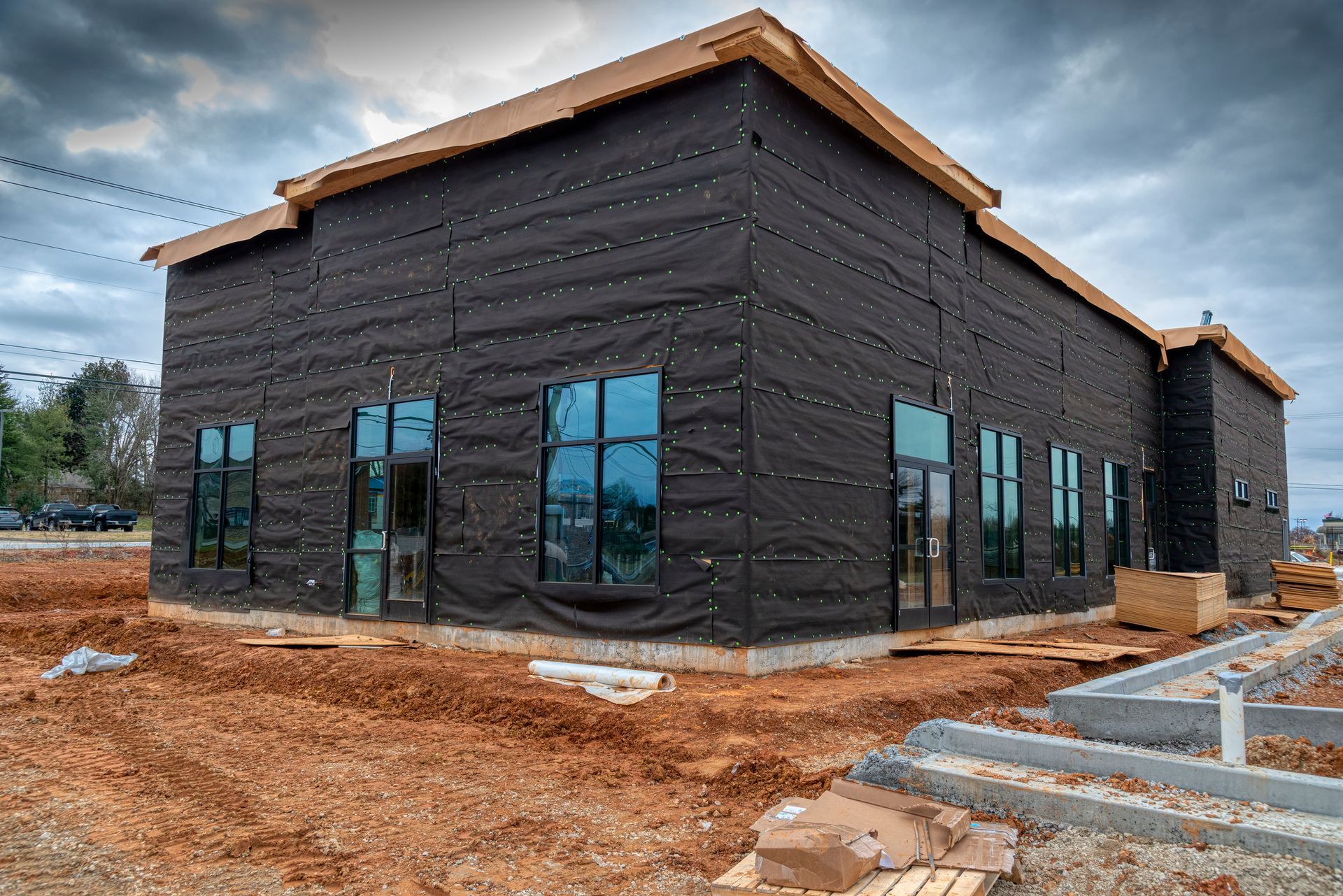A building is being built with scaffolding and snow on the ground.