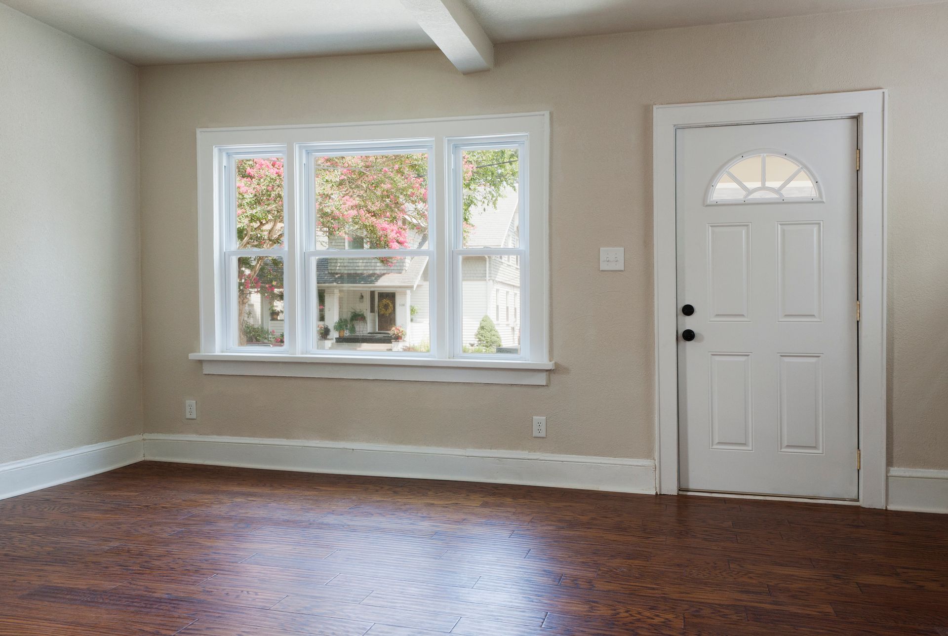 An empty room with gray walls and two windows
