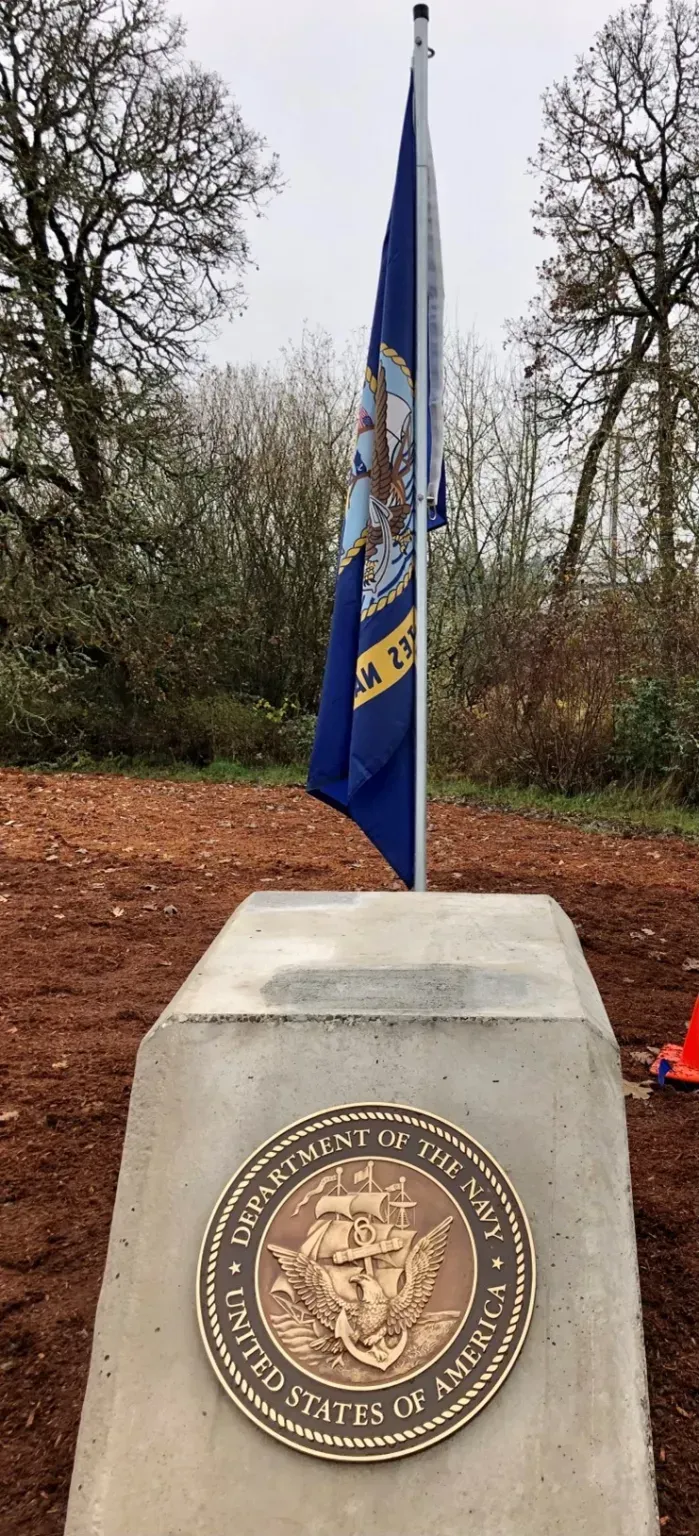 A flag is flying on top of a concrete pedestal.