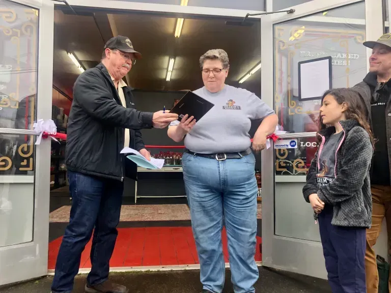 A group of people are standing in front of a store.