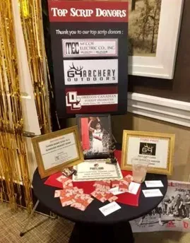 A table with a sign that says top scrip donors