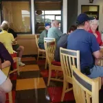 A group of people are sitting at tables in a restaurant.