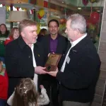A group of men are standing in a room holding a plaque.