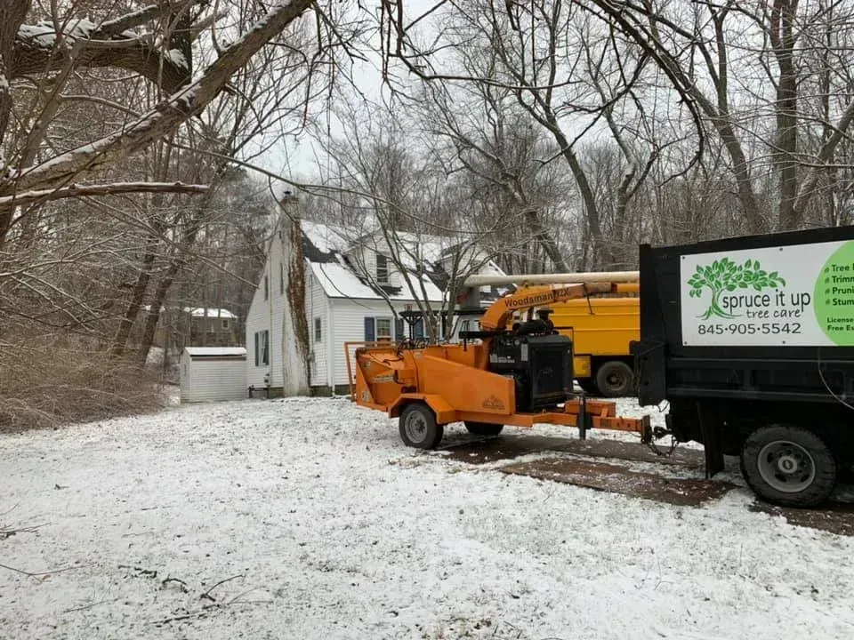 An orange wood chipper hitched to a truck with 
