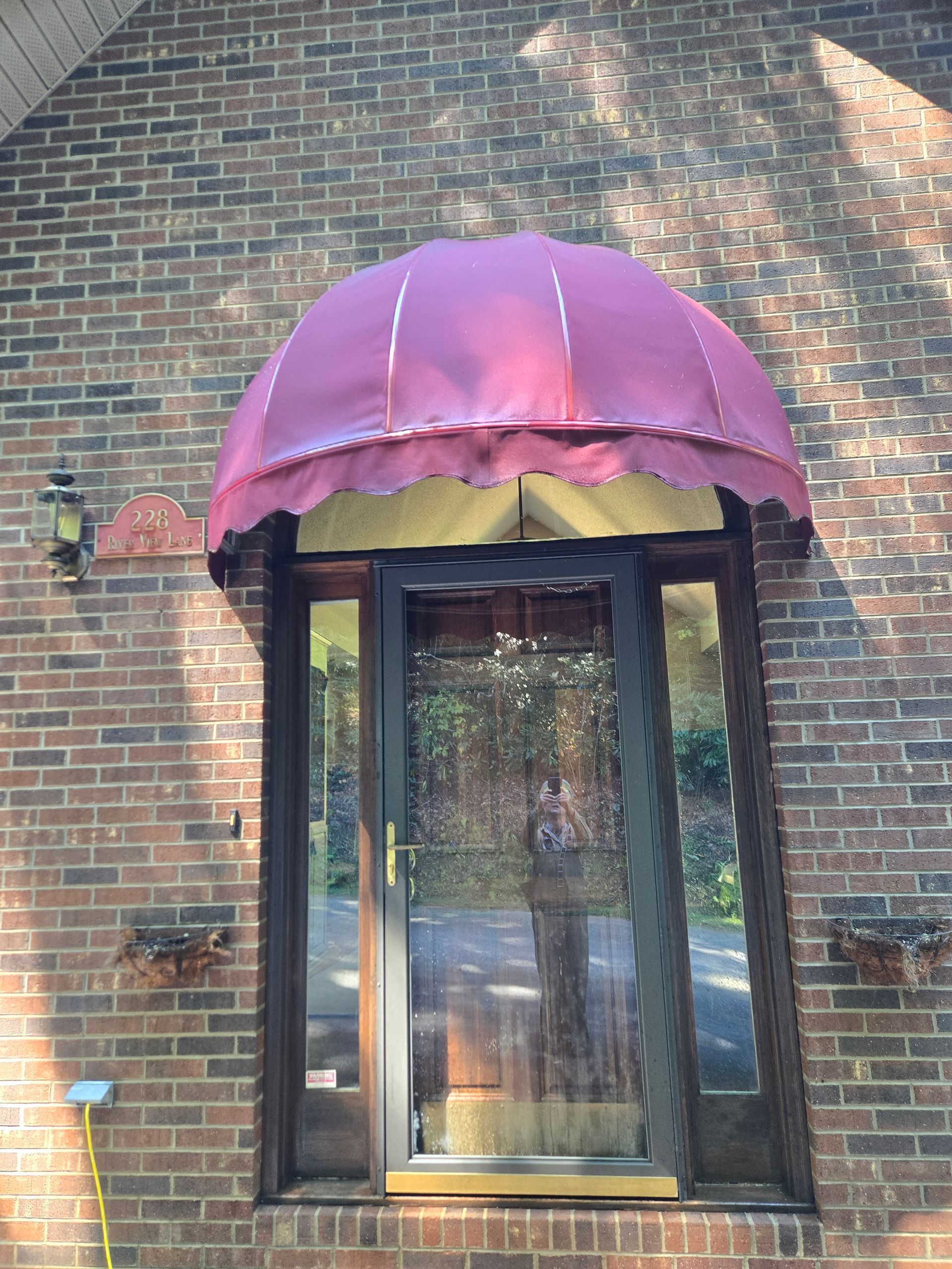 A brick building with a purple awning over a door