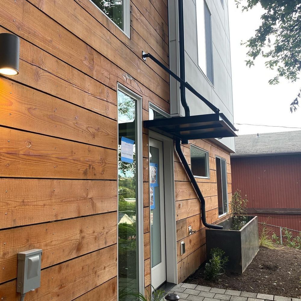 A wooden house with a staircase leading up to the front door