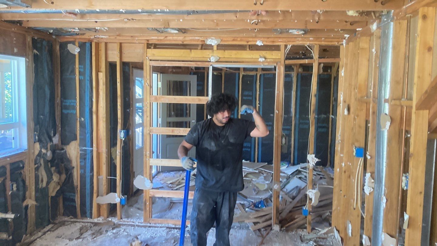 A man is standing in a room that is being remodeled.