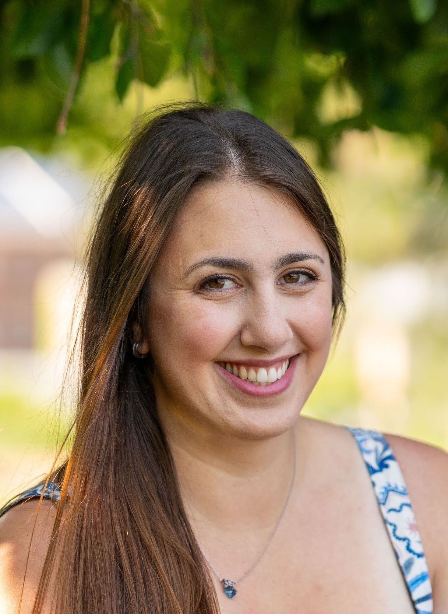 A woman with long red hair is smiling and wearing a black shirt.