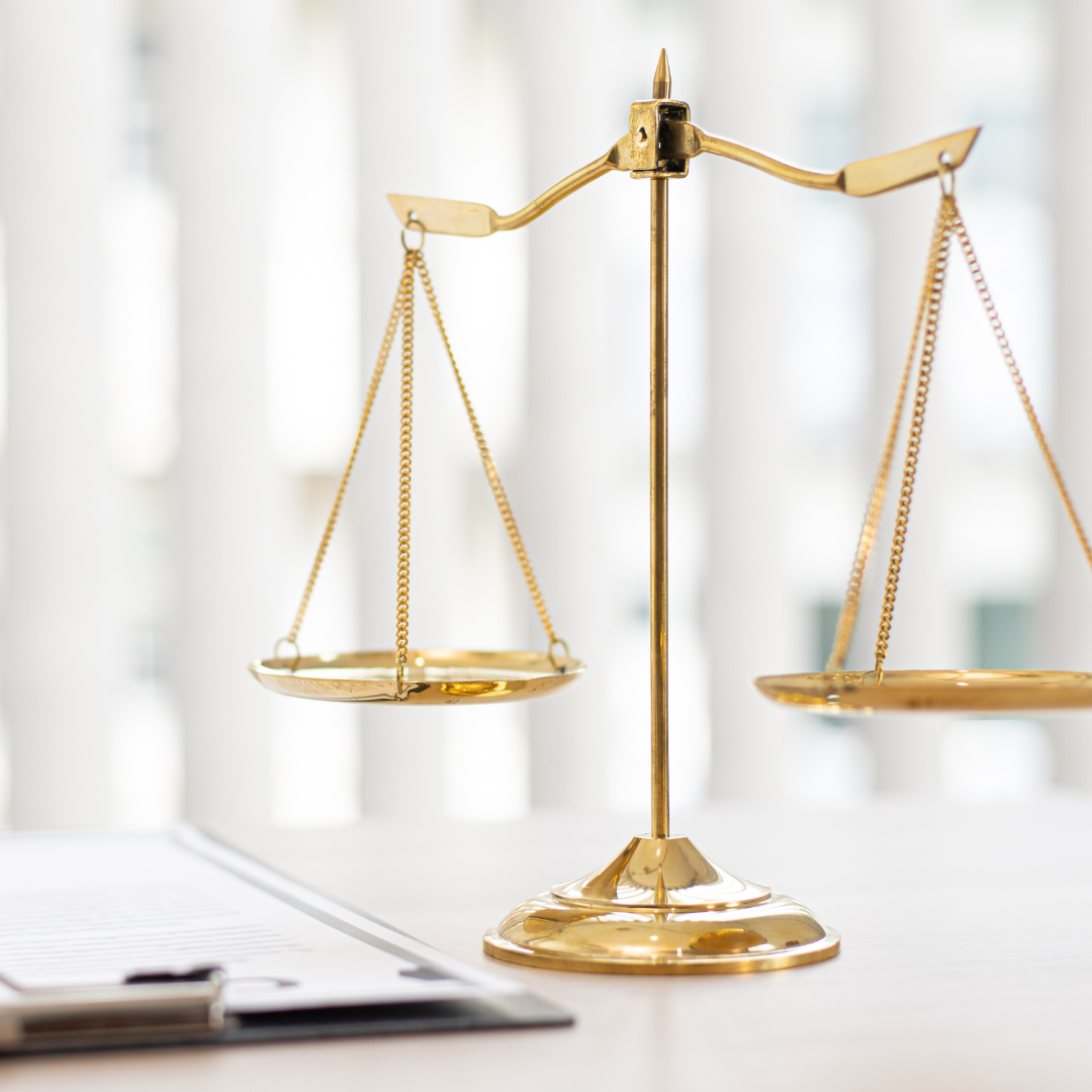 A gold scale is sitting on a table next to a clipboard