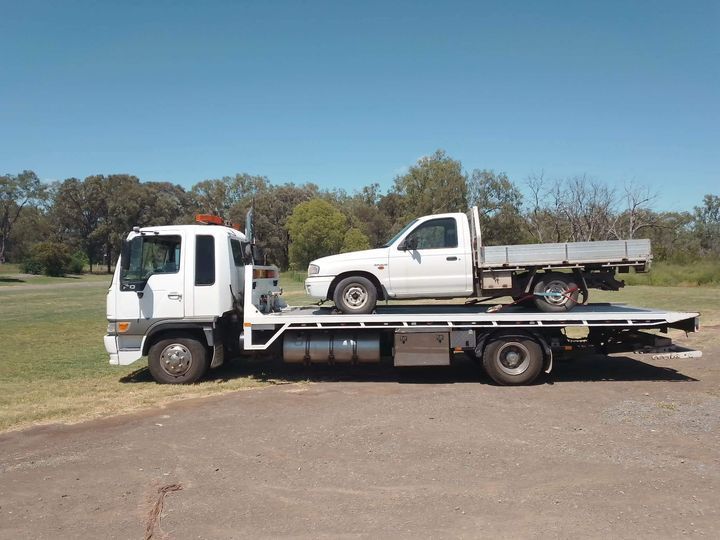 A Tow Truck With Two Cars On The Back Of It — Offset Tilt Trays In Biloela, QLD