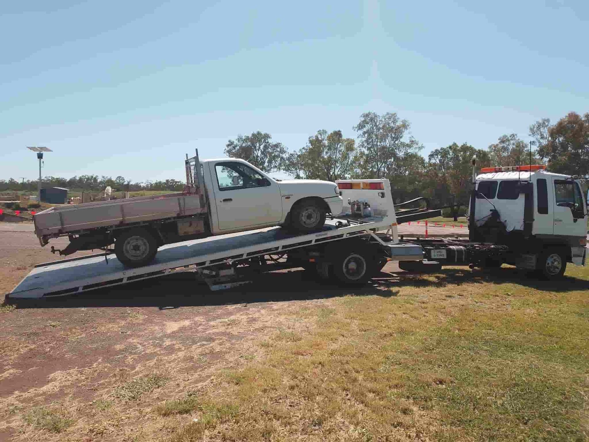 A White Truck Is Being Towed By A Tow Truck — Offset Tilt Trays In Biloela, QLD