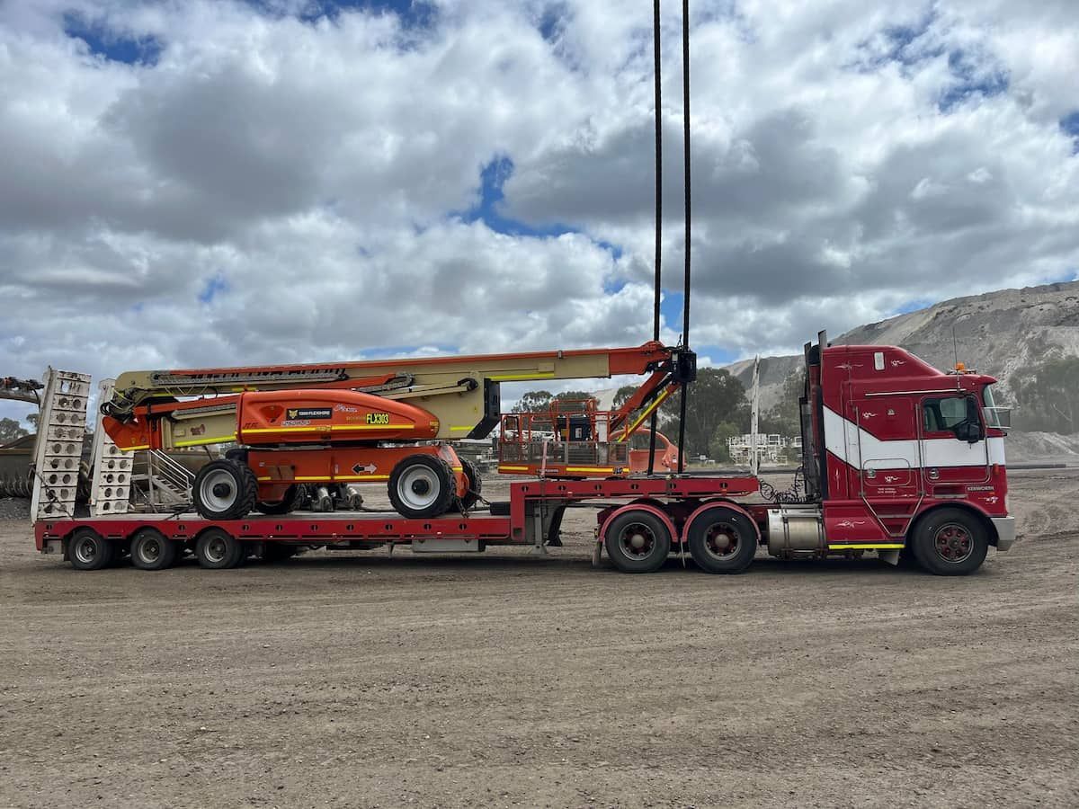 A White Tow Truck With Tires On The Back Is Parked In A Dirt Lot — Offset Tilt Trays In Biloela, QLD