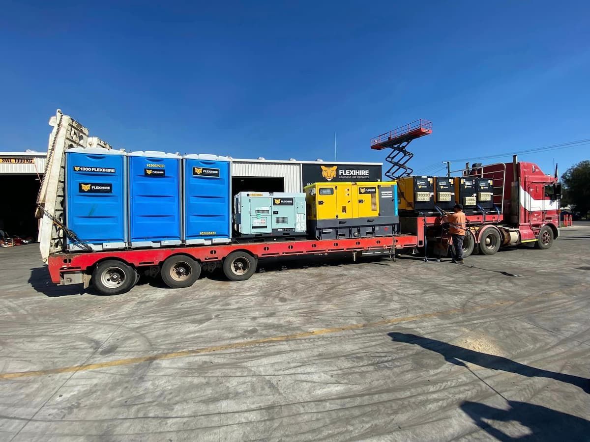 A Truck Is Carrying a Trailer Full of Portable Toilets — Offset Tilt Trays In Biloela, QLD