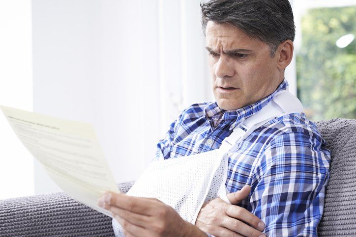 Mature Man Reading Letter About Injury