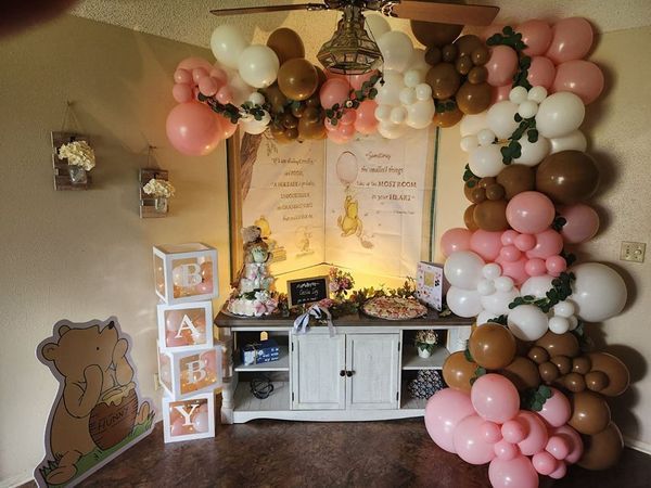 A room decorated with balloons for a baby shower.