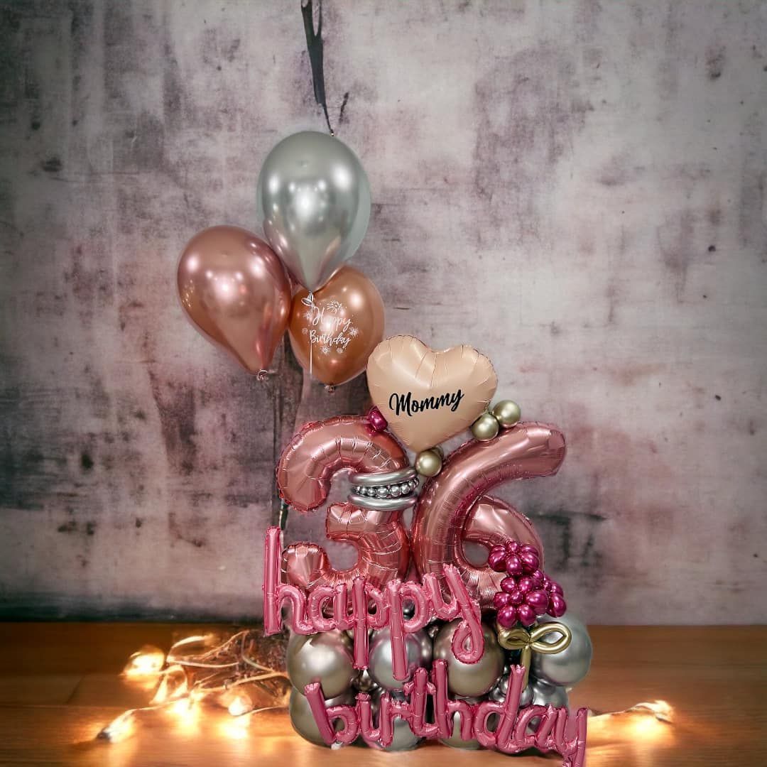 A bunch of balloons and a sign that says happy birthday are on a table.