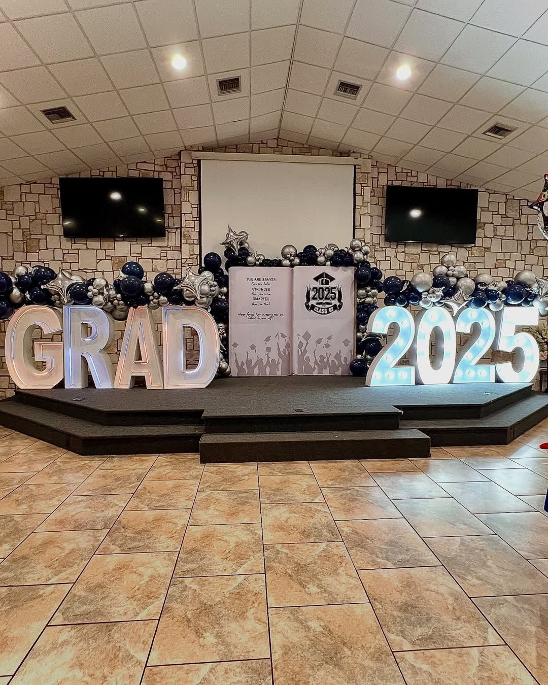 A large room with balloons and letters that say `` grad 2025 ''.