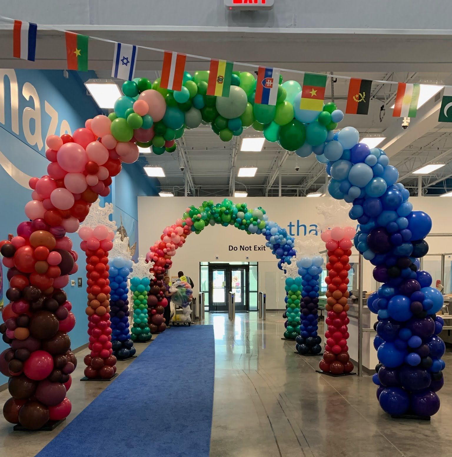 A bunch of balloons in a room with a sign that says this