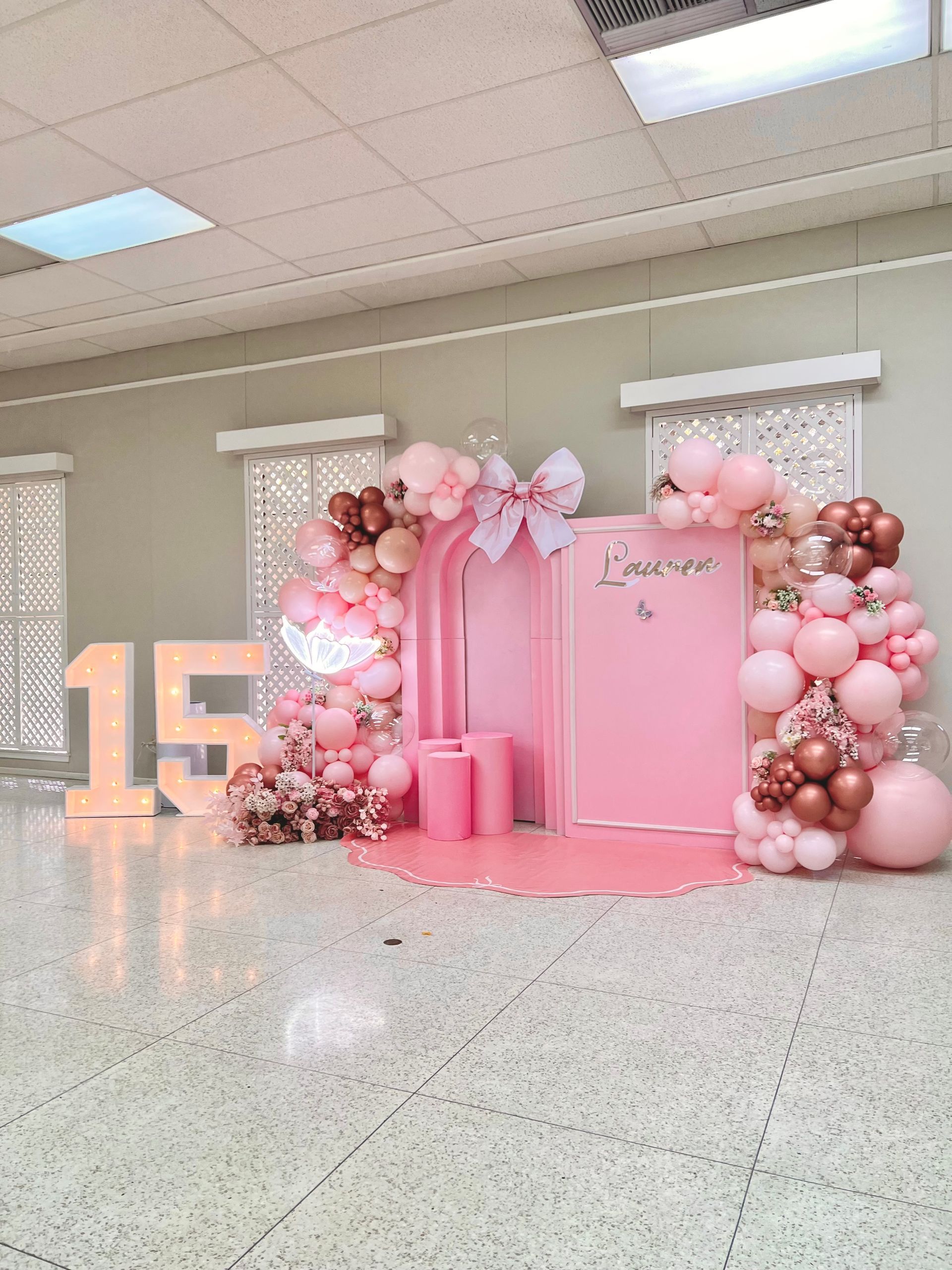 A room decorated with pink balloons and a sign that says 15.