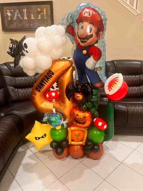 Mario-themed balloon arrangement for a fourth birthday. Includes Mario, a numbered balloon, and various game characters.