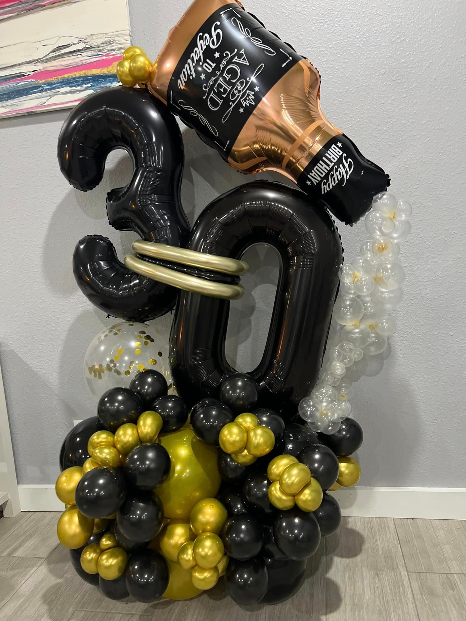 A bottle of jack daniels is pouring out of a balloon in the shape of the number 30.