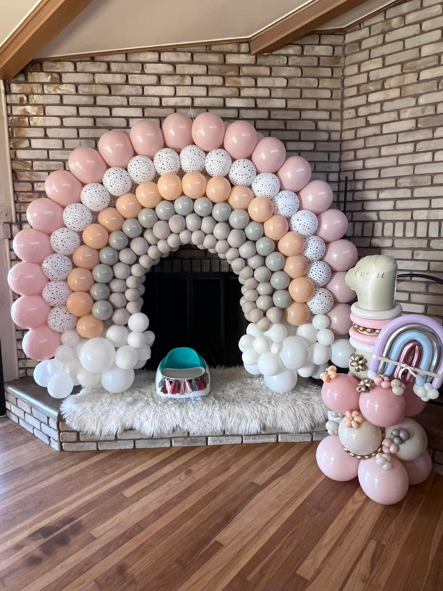 A fireplace decorated with balloons in the shape of a rainbow.