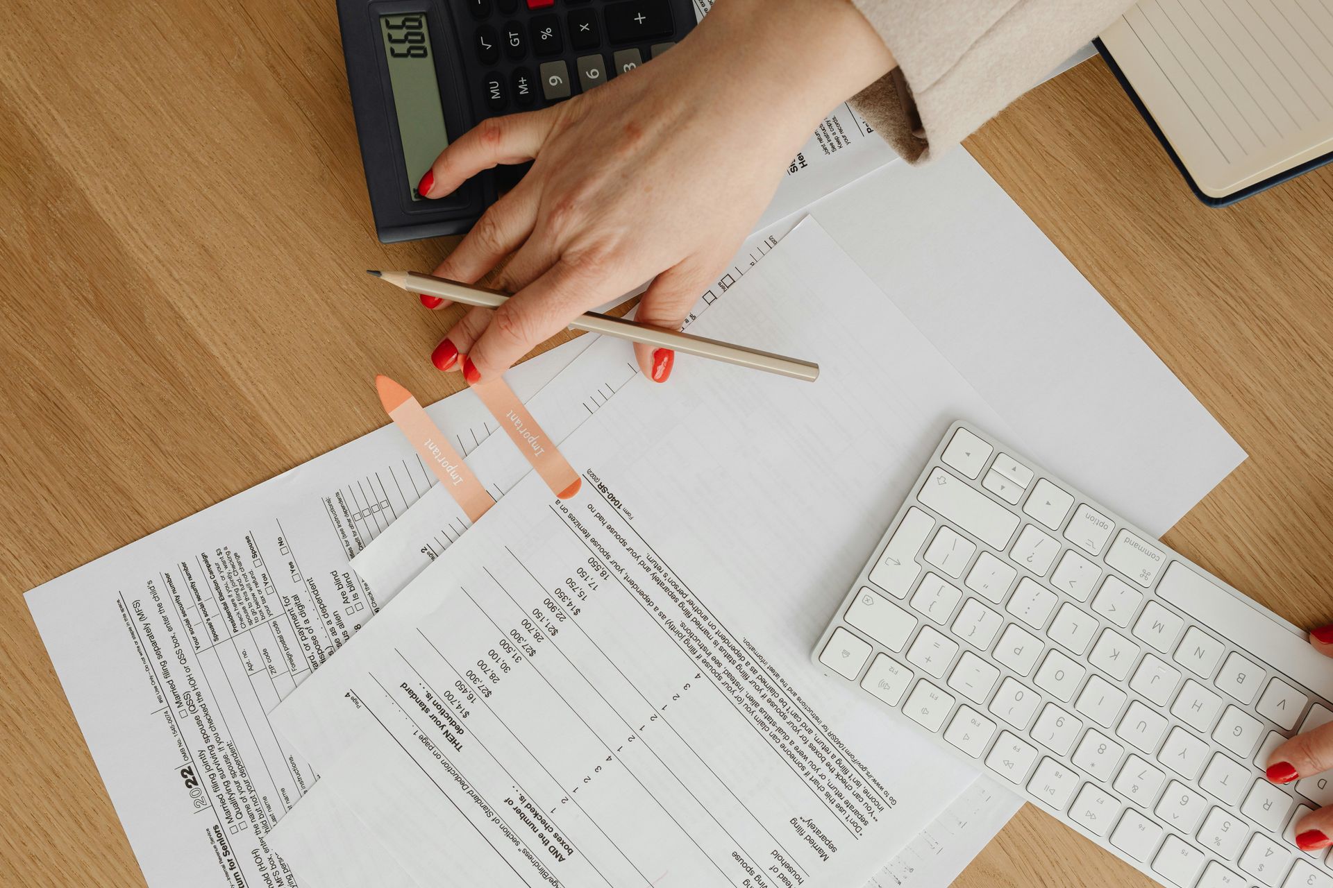 A woman is using a calculator to calculate a bill.