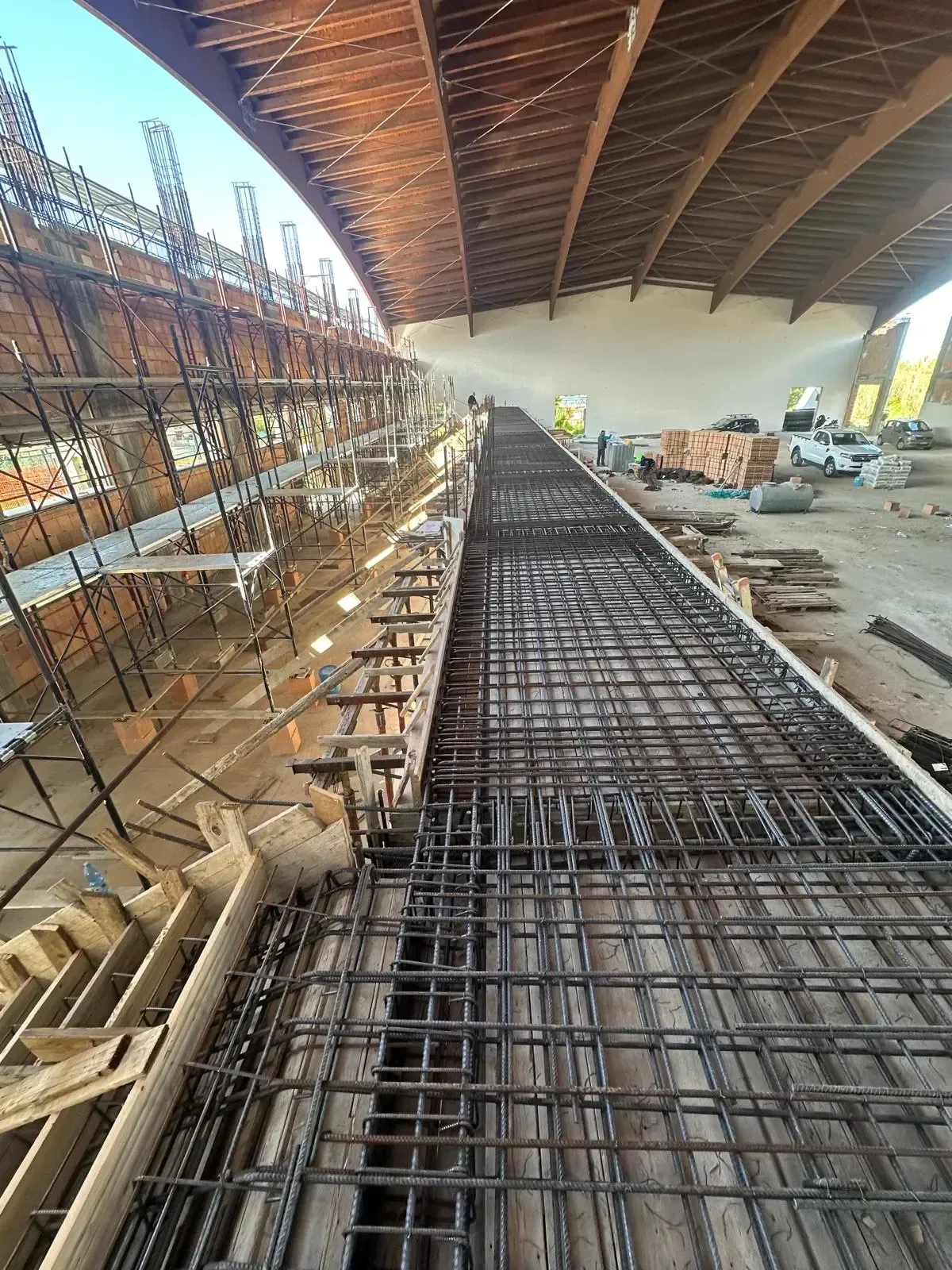 Un'auto bianca è parcheggiata accanto a un edificio chiaro. L'auto si trova su un'area asfaltata vicino a un muro.