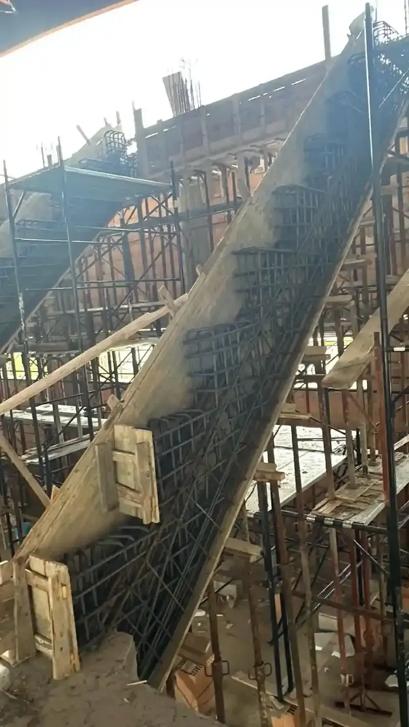 Cantiere con struttura in calcestruzzo parzialmente realizzata e armatura in acciaio.