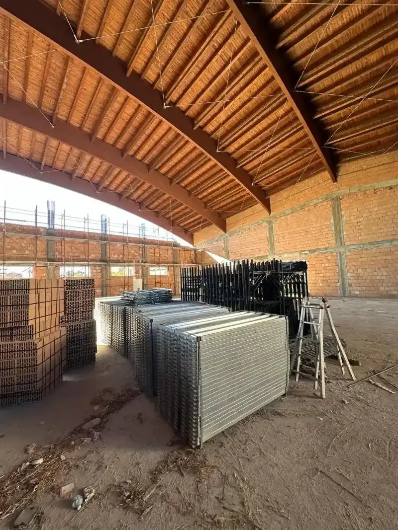 All'interno di un edificio in mattoni in costruzione: pile di rete metallica e materiali da costruzione.