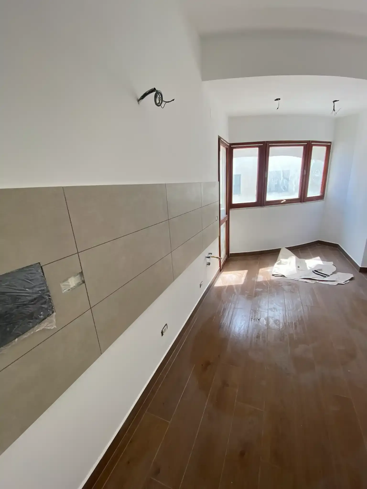 Costruzione interna: una stanza con pareti grezze, pavimento in legno e una finestra.