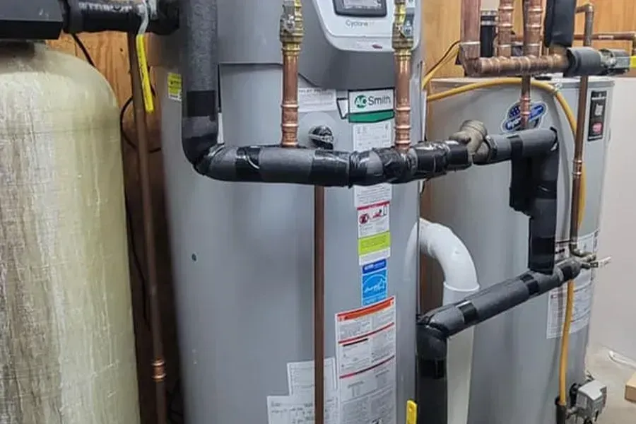 Two water heaters are sitting next to each other in a room.