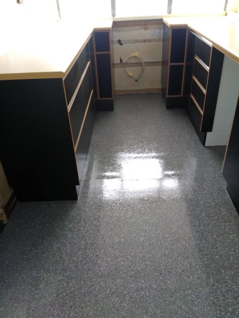 Kitchen With a Gray Floor and Black Cabinets — Australian Epoxy Floors in Rockhampton, QLD