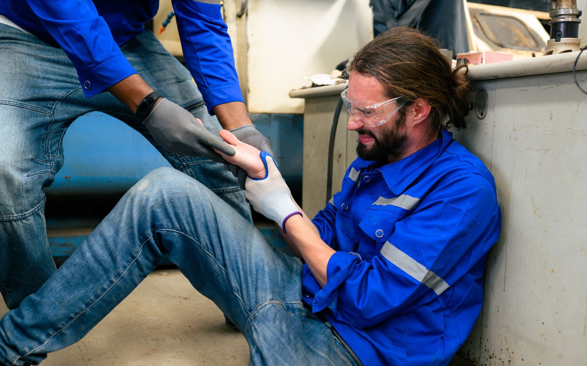A man is sitting on the floor with a wrist injury.