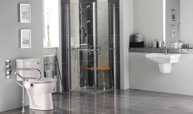 A bathroom with a toilet , sink , shower and mirror.