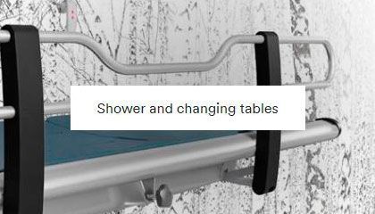 A shower and changing table is hanging on a wall.