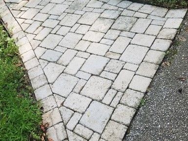 a sidewalk made of bricks next to a road .