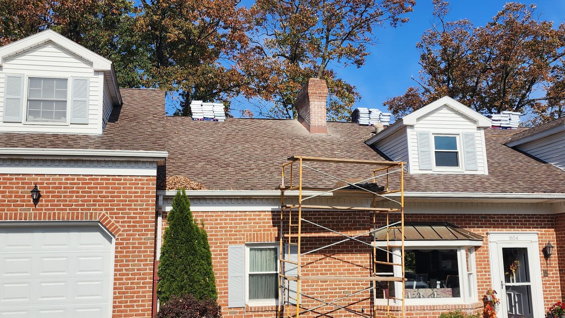 A brick house with a scaffolding in front of it.