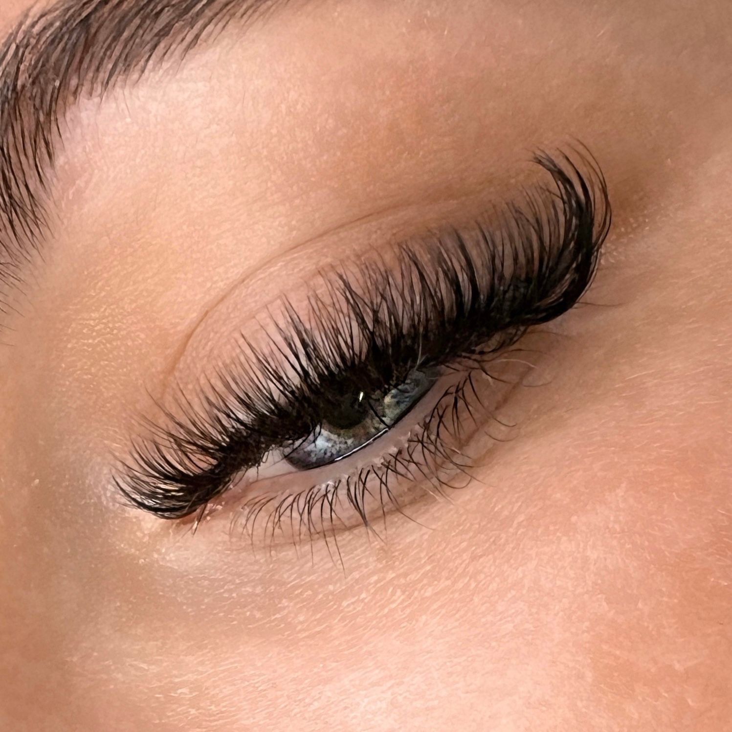 Eine Nahaufnahme des Auges einer Frau mit langen Wimpern.